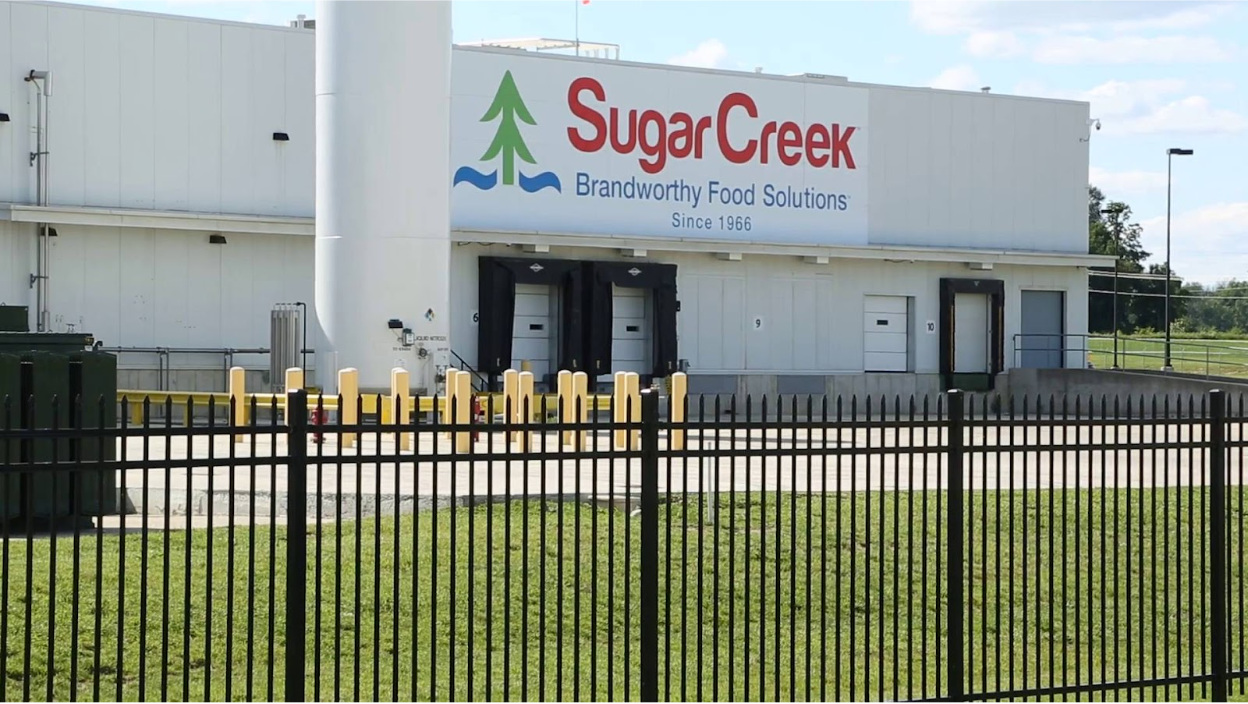 Picture of a SugarCreek facility with a sign that says "SugarCreek, Brandworthy Food Solutions Since 1966"